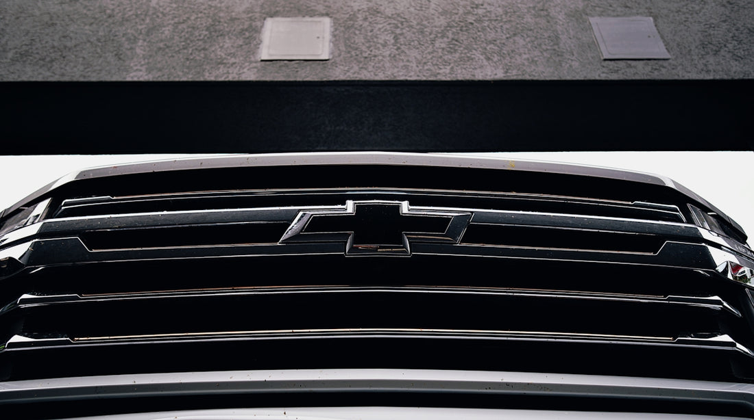 A chevrolet grill, close-up, gleaming in the light.