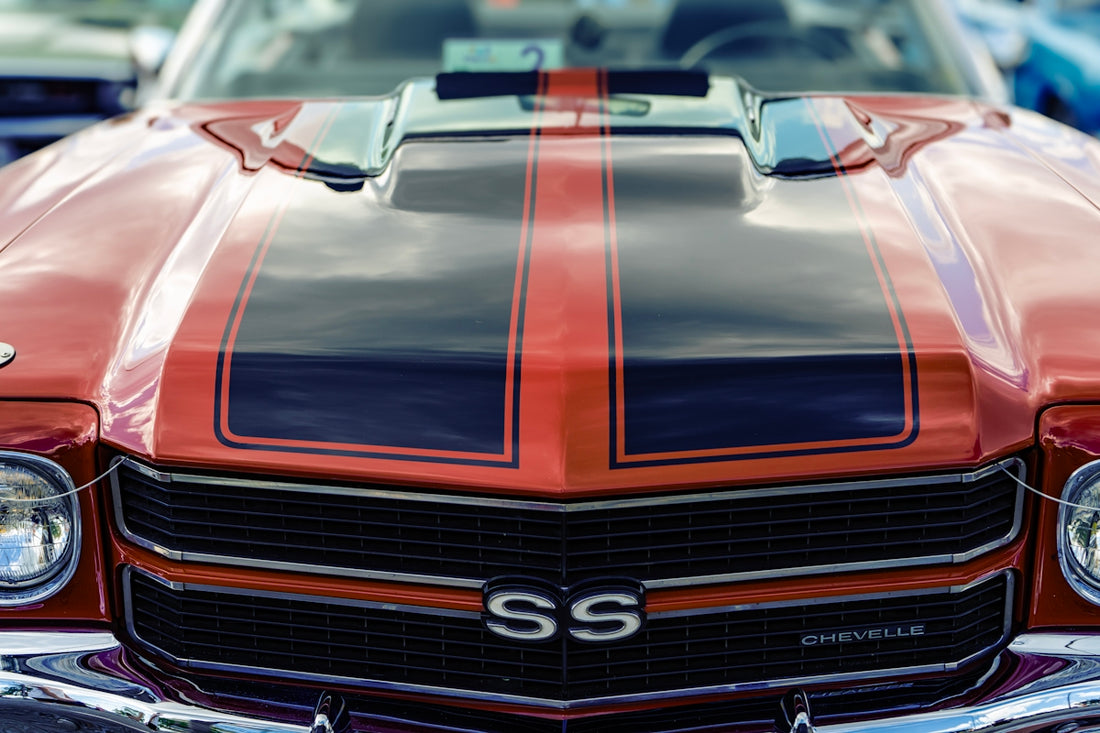 Red vintage car with black racing stripes