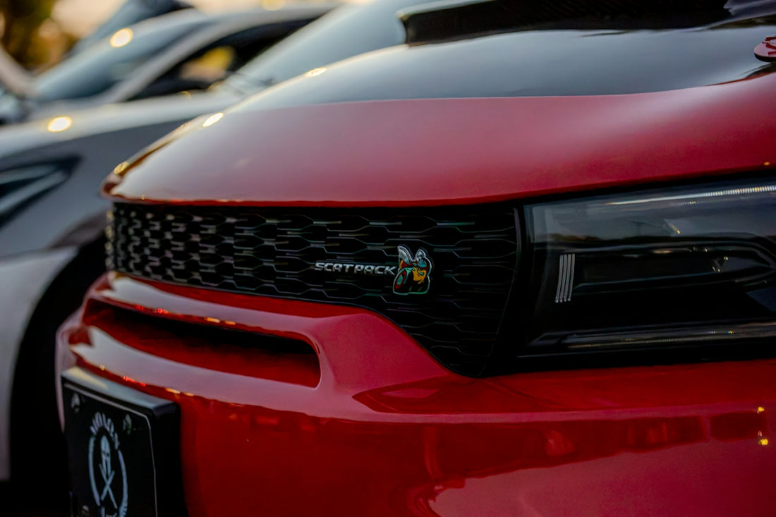 A red car front grille with a Scat Pack bee emblem